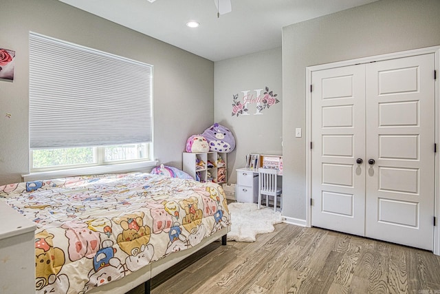 bedroom with hardwood / wood-style floors, a closet, and ceiling fan