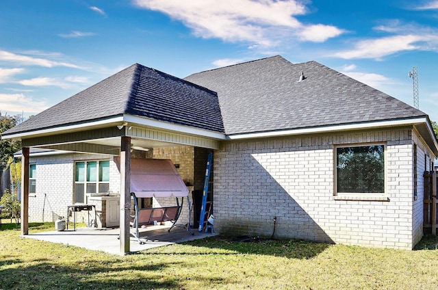 rear view of property with a patio and a lawn