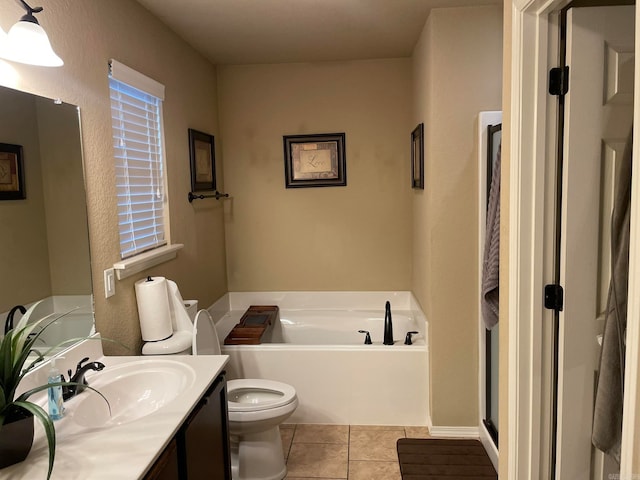 bathroom with vanity, toilet, a tub to relax in, and tile patterned flooring