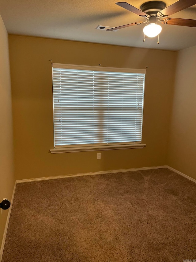 unfurnished room with ceiling fan and carpet