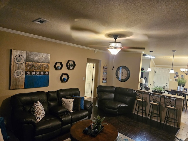 living room with crown molding, wood-type flooring, and a textured ceiling