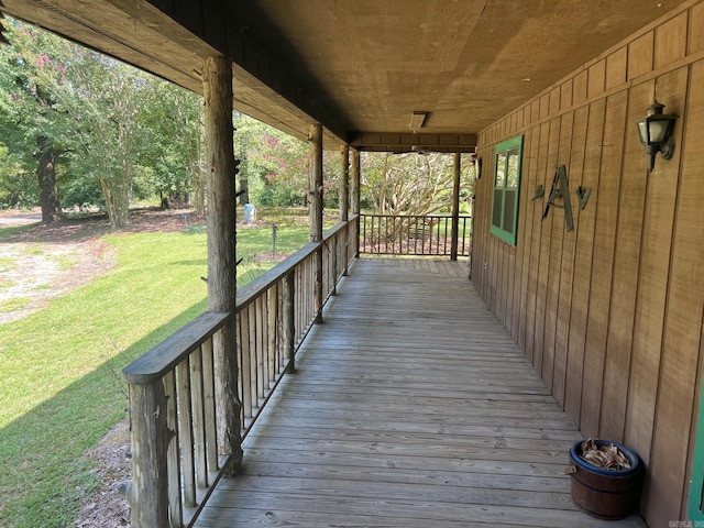 wooden deck featuring a lawn and a porch