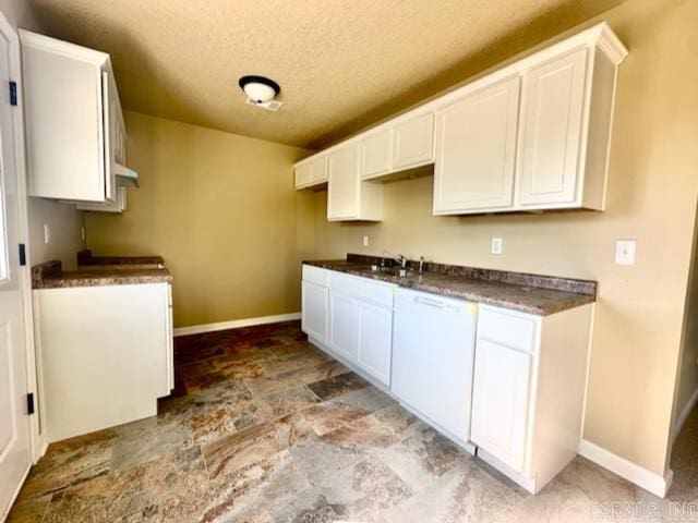 kitchen with white cabinetry, a textured ceiling, and sink