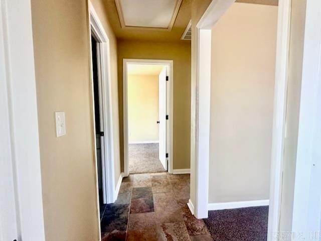 corridor featuring dark colored carpet