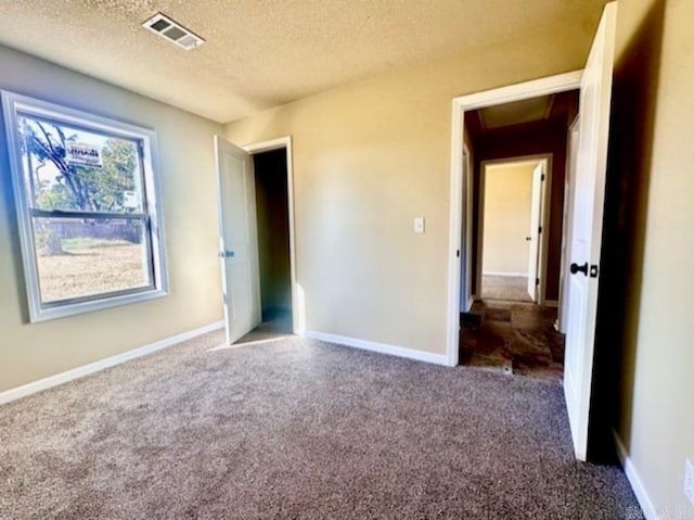 unfurnished bedroom with a textured ceiling and carpet flooring