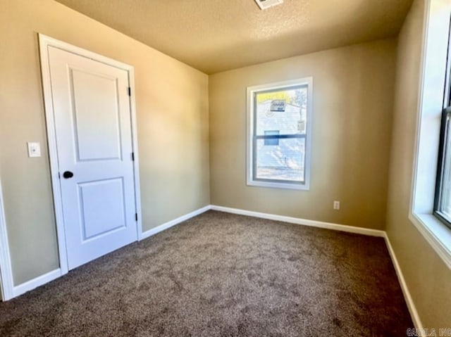 carpeted spare room featuring a textured ceiling