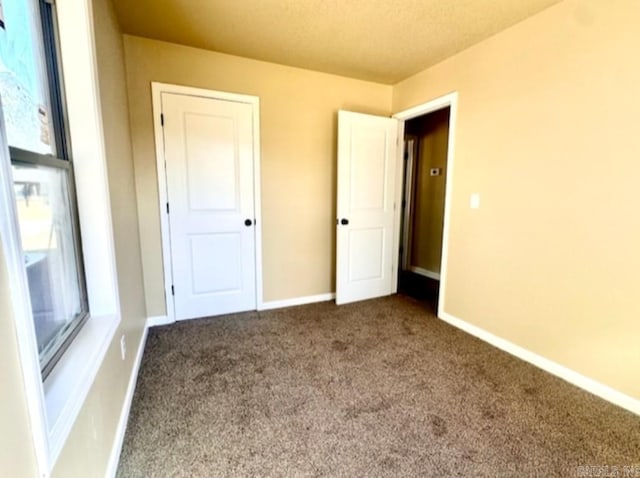 unfurnished bedroom with carpet and a textured ceiling