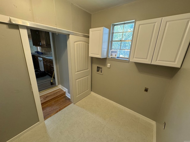 washroom featuring light hardwood / wood-style flooring, electric dryer hookup, washer hookup, and cabinets