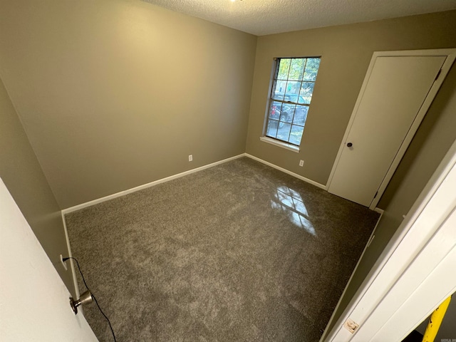 empty room with carpet and a textured ceiling