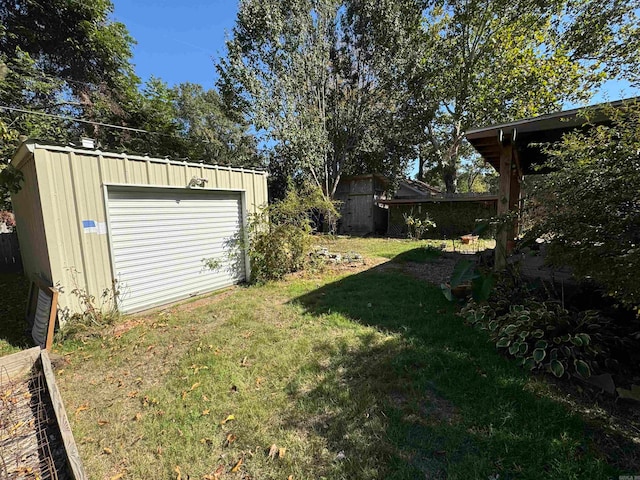 view of yard featuring a garage and an outdoor structure