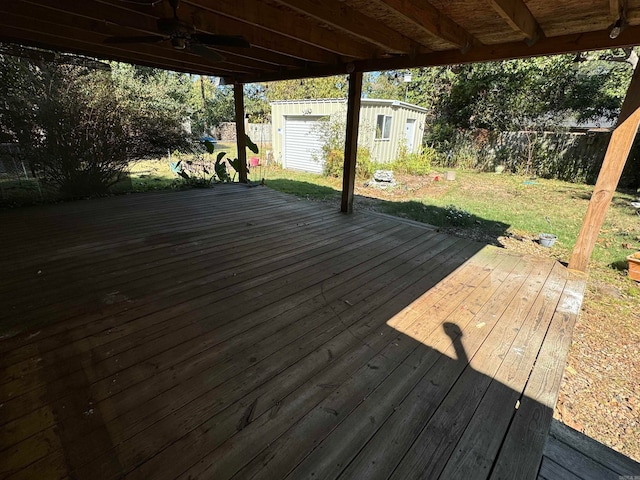 deck with a shed and a lawn