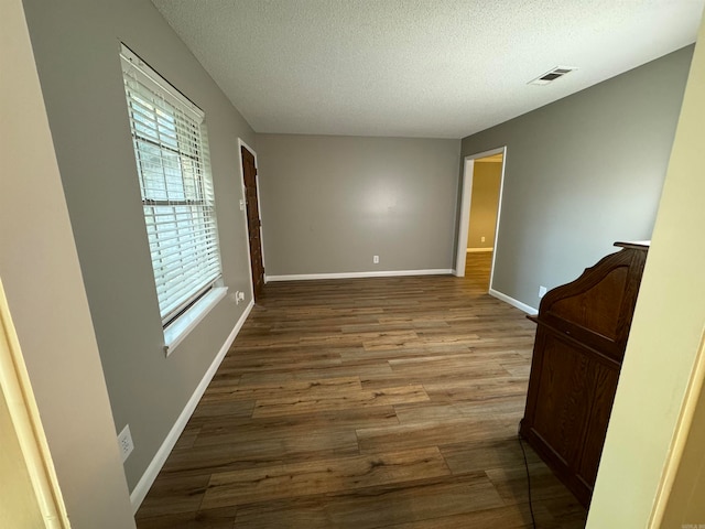 empty room with a textured ceiling and hardwood / wood-style flooring