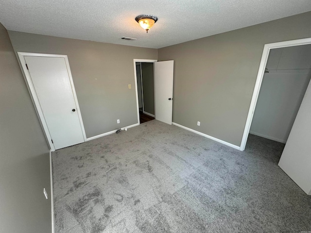 unfurnished bedroom featuring a textured ceiling and carpet flooring