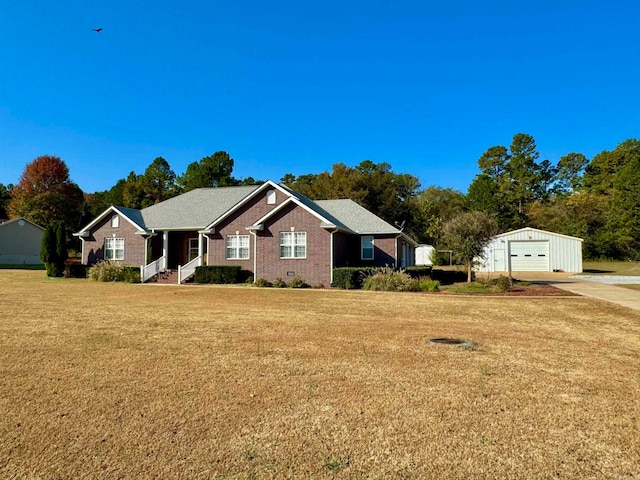 single story home with a front lawn, an outbuilding, and a garage