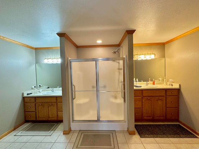 bathroom with a shower with door, a textured ceiling, vanity, ornamental molding, and tile patterned flooring