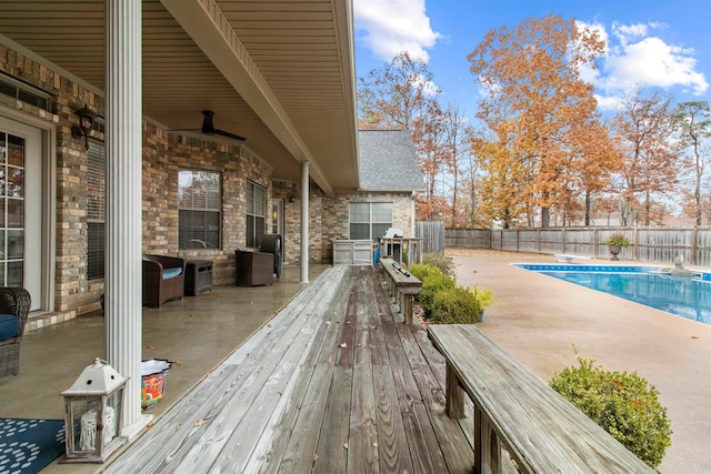 deck with a patio area and a fenced in pool