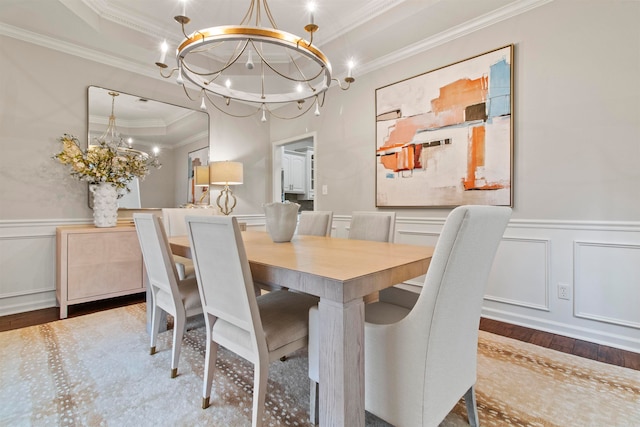 dining room featuring crown molding, a notable chandelier, hardwood / wood-style flooring, and a raised ceiling