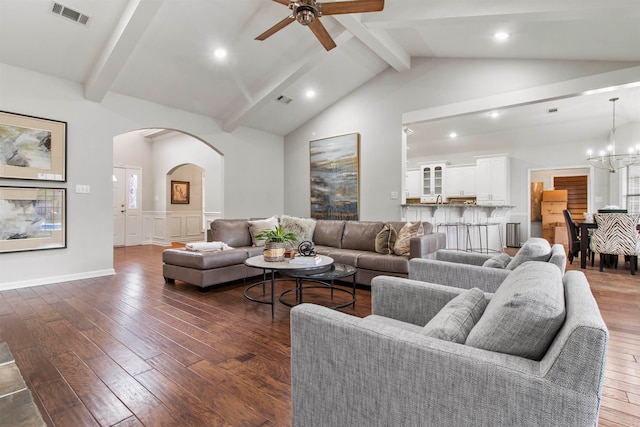 living room featuring dark wood-type flooring, vaulted ceiling with beams, and ceiling fan with notable chandelier