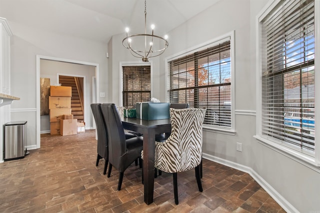 dining area featuring a wealth of natural light and an inviting chandelier