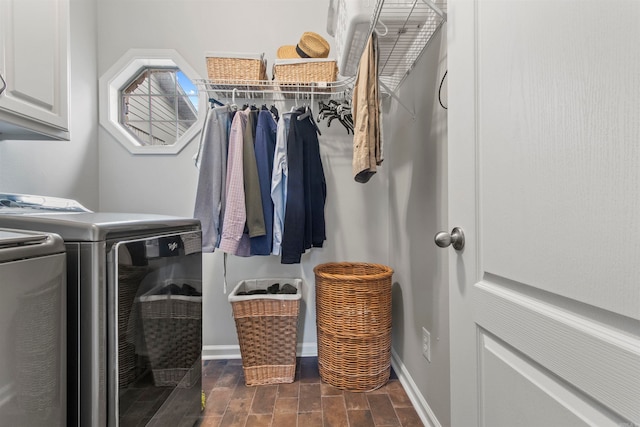 washroom featuring cabinets and washer and clothes dryer