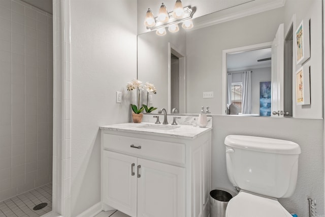 bathroom featuring toilet, vanity, and tiled shower