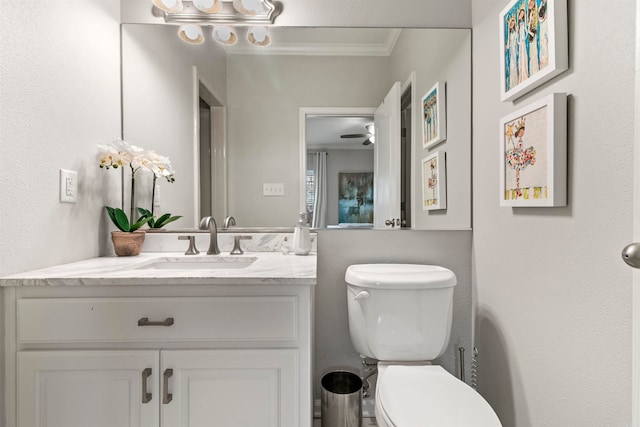 bathroom featuring vanity, toilet, ornamental molding, and ceiling fan