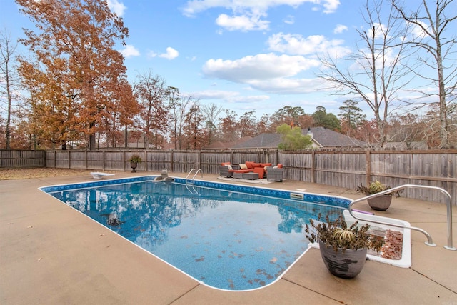 view of swimming pool featuring a patio and a diving board