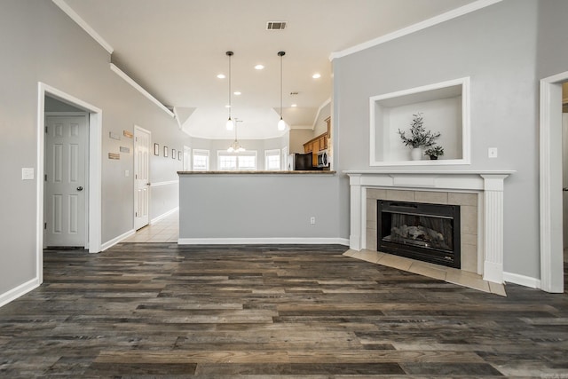 18 Emma Dr, Cabot, AR 72023 - unfurnished living room featuring ornamental molding, baseboards, dark wood-style flooring, a tiled fireplace, and recessed lighting