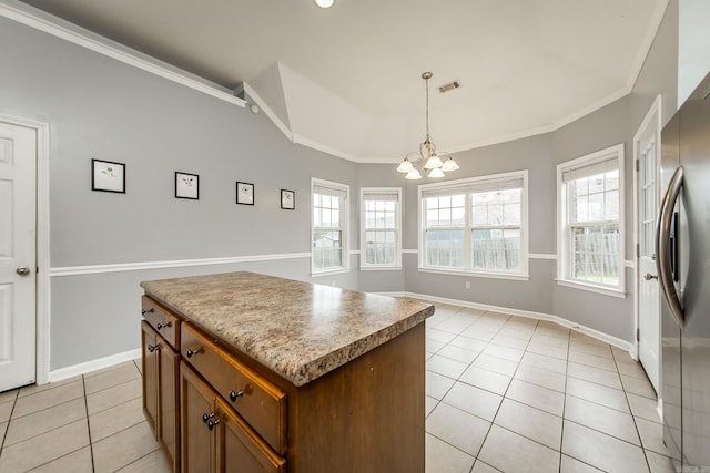 18 Emma Dr, Cabot, AR 72023 - kitchen with light tile patterned floors, a chandelier, freestanding refrigerator, a kitchen island, and pendant lighting