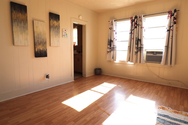 spare room with cooling unit and wood-type flooring