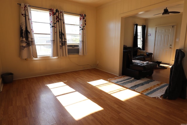 interior space featuring ceiling fan, cooling unit, light hardwood / wood-style flooring, and ornamental molding