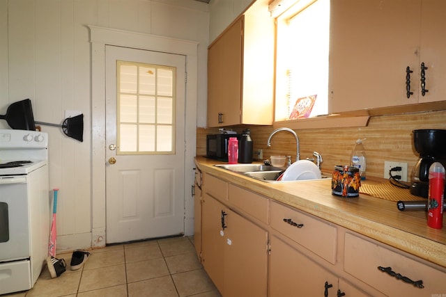 kitchen featuring light tile patterned flooring, white electric range, plenty of natural light, and sink