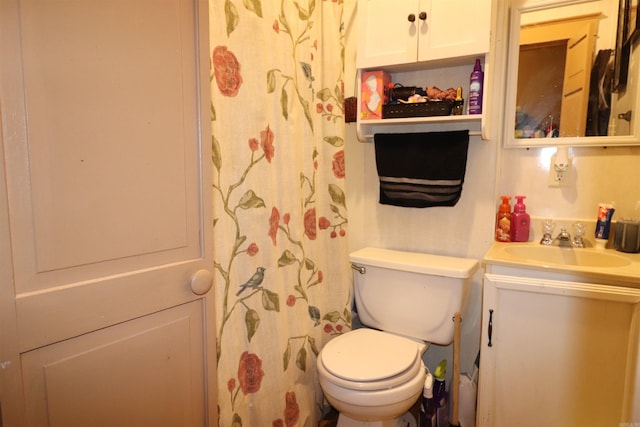 bathroom with toilet, vanity, and curtained shower