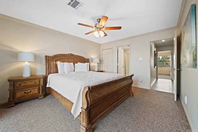 carpeted bedroom with crown molding, a textured ceiling, a closet, and ceiling fan