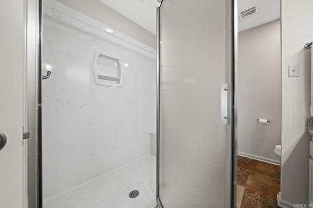 bathroom featuring toilet and an enclosed shower