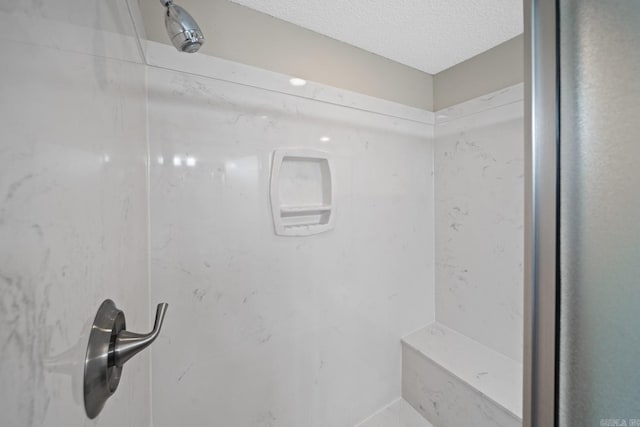 bathroom featuring a textured ceiling and walk in shower