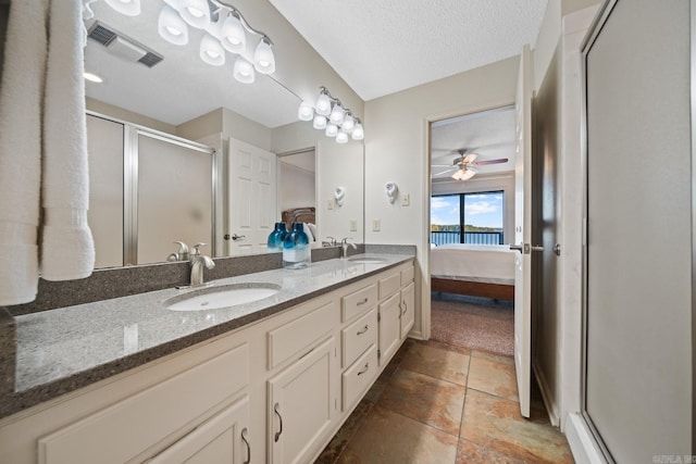 bathroom featuring vanity, a textured ceiling, a shower with shower door, and ceiling fan