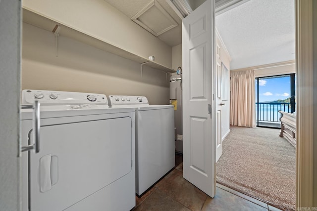 laundry area featuring washer and dryer, a textured ceiling, and dark colored carpet