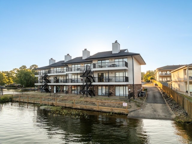 rear view of house with a balcony and a water view