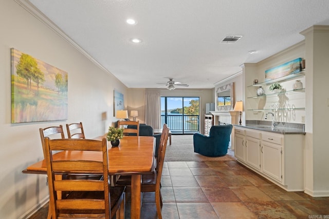 dining space featuring ceiling fan, a textured ceiling, ornamental molding, and sink