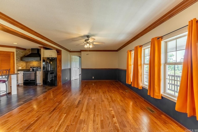 unfurnished living room with ornamental molding, hardwood / wood-style floors, and ceiling fan