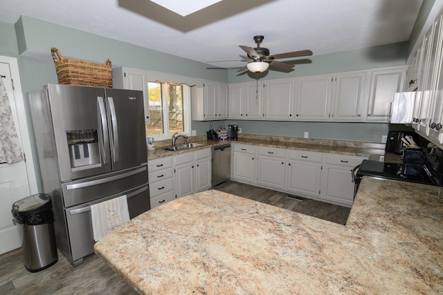 kitchen featuring ceiling fan, appliances with stainless steel finishes, white cabinetry, dark hardwood / wood-style floors, and sink