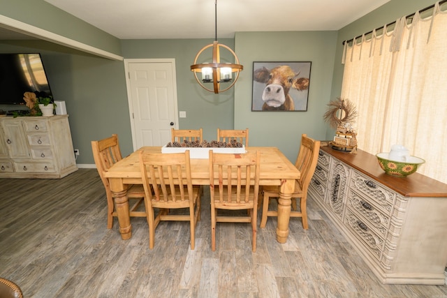 dining space featuring hardwood / wood-style floors and an inviting chandelier