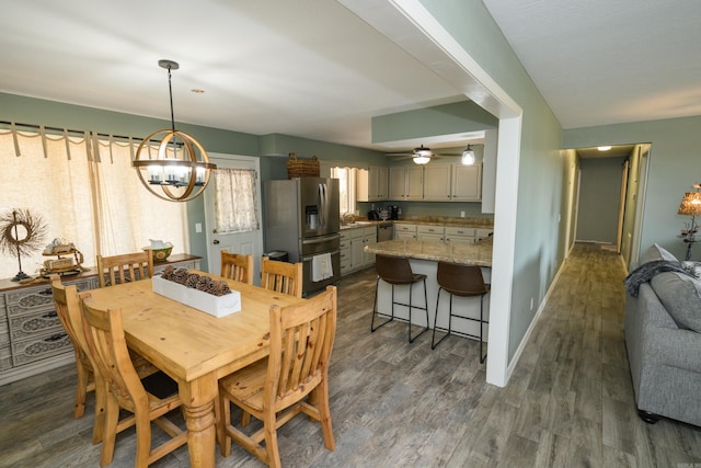 dining room with sink, a chandelier, and dark hardwood / wood-style flooring