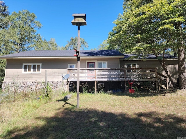 back of house featuring a deck and a lawn