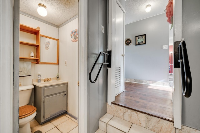 bathroom with vanity, hardwood / wood-style floors, toilet, and a textured ceiling