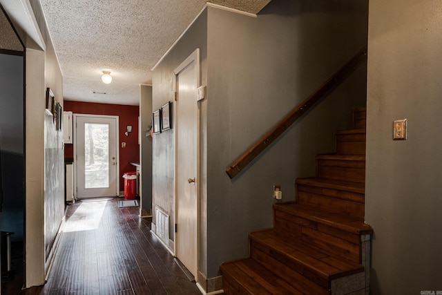 foyer with a textured ceiling and dark hardwood / wood-style flooring