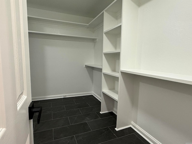 walk in closet featuring dark tile patterned floors