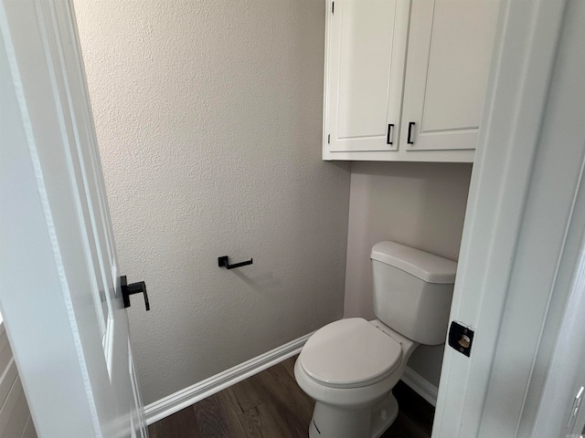 bathroom with hardwood / wood-style flooring and toilet