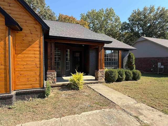 property entrance featuring a yard and covered porch